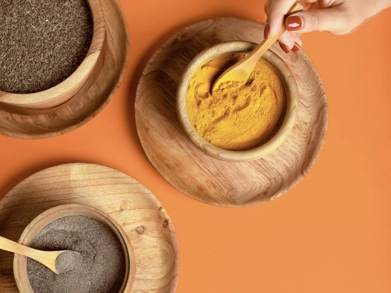 A wooden spoon in a bowl of fine yellow powder