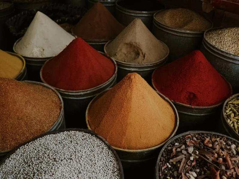 Cones of ground spices in steel tubs